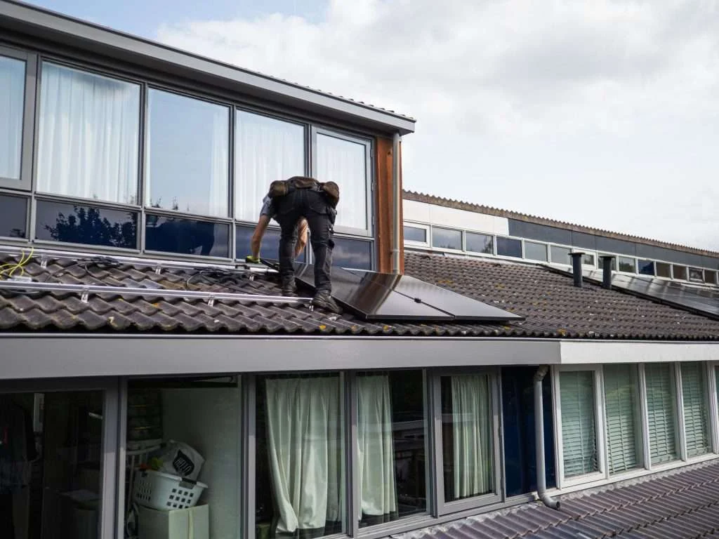 A technician installing solar panels on a rooftop